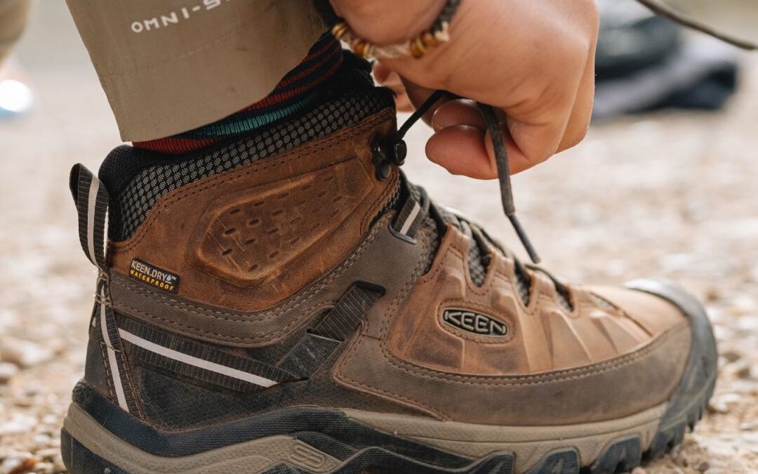 man lacing up keen shoe